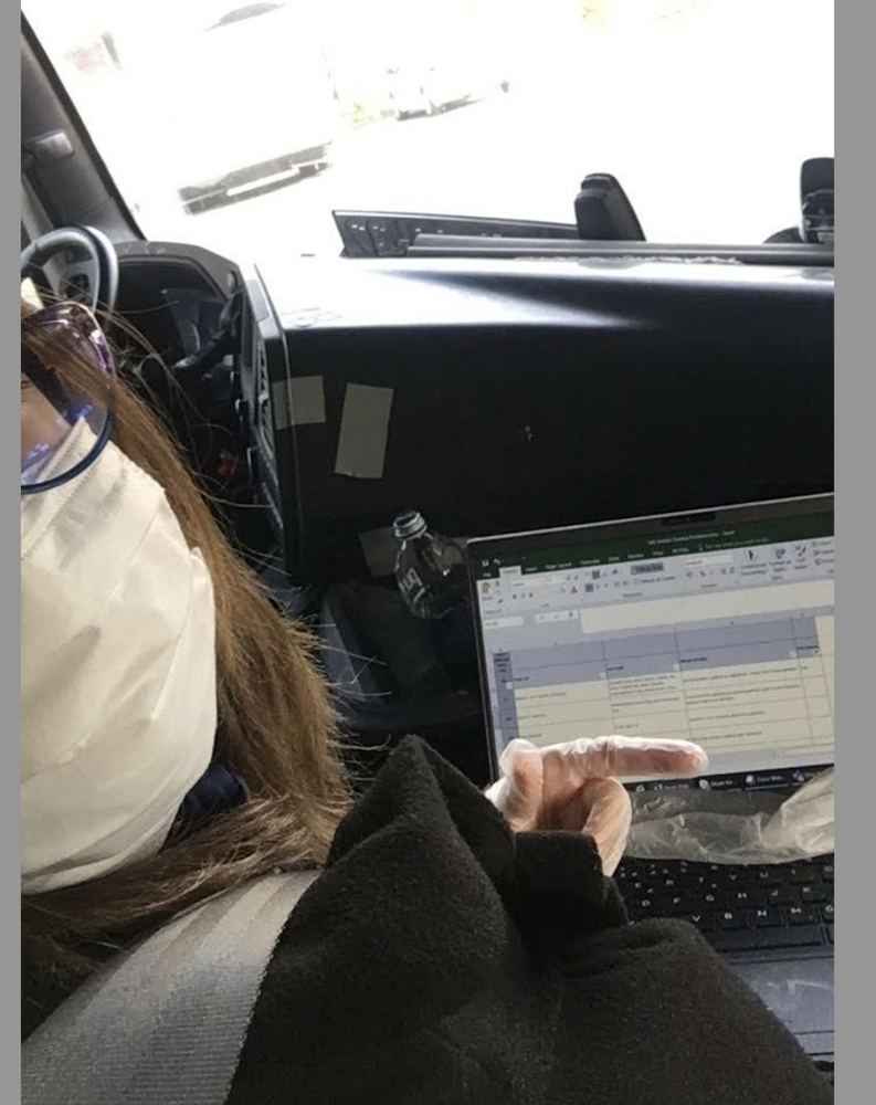 Sitting in a vehicle with a laptop, working through a test sheet.